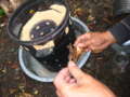 図 3c: 次に、任意の形式の焚き付け (たとえば、乾燥したとげを使用) を使用して、籾殻に内側から点火します。