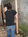 Fig. 2b: Brianna and Zach filling holes with sand to secure the wood beams in place