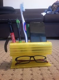 Multipurpose cell-phone dock with slots for stationery and a pair of specs.jpg