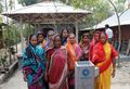 Bangladeshi Women stand behind a completed concrete BioSand Filter.