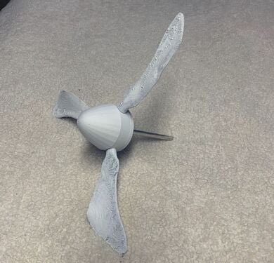 Slot the 3D-printed turbine blades into their centerpiece, paint them white, and connect to the metal rod